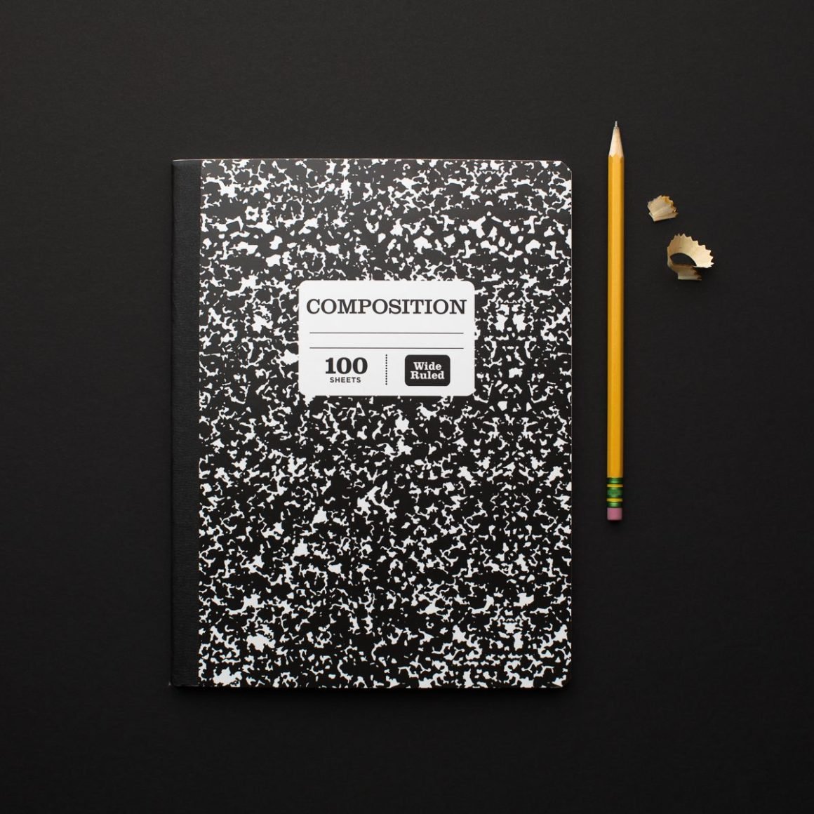 composition notebook with yellow pencil